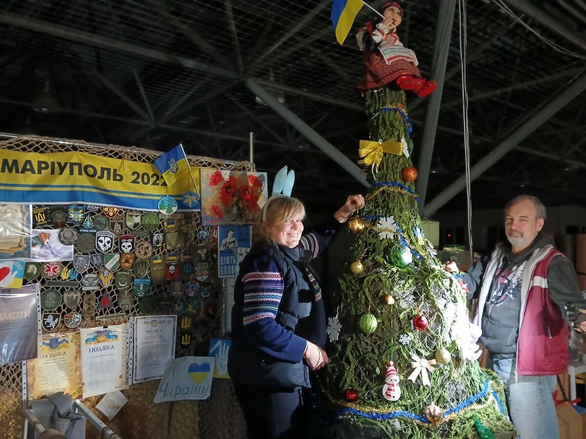 Mykhailo and Iryna near a Christmas tree made of camouflage netting Mykhailo and Iryna near a Christmas tree made of camouflage netting